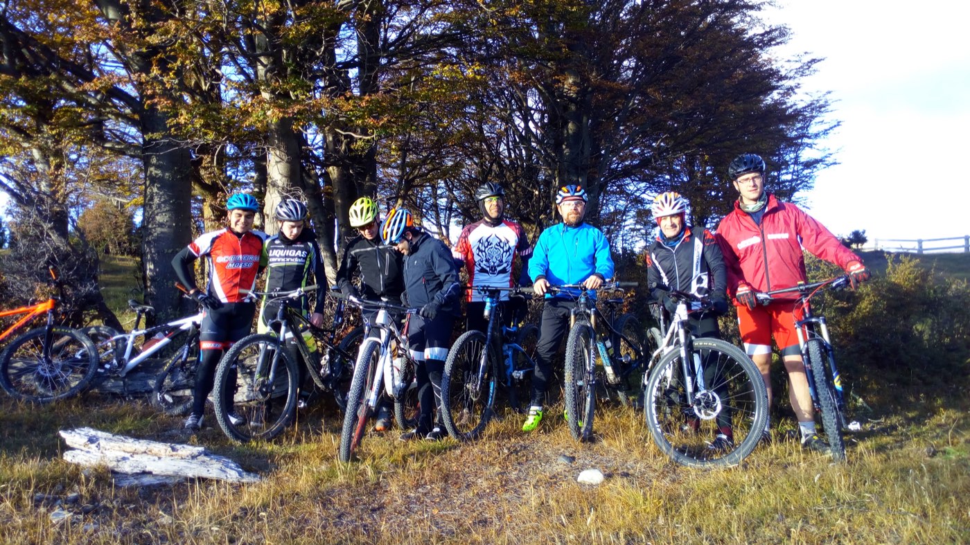 Grupo del club con sus bicicletas en un bosque de lengas en otoño